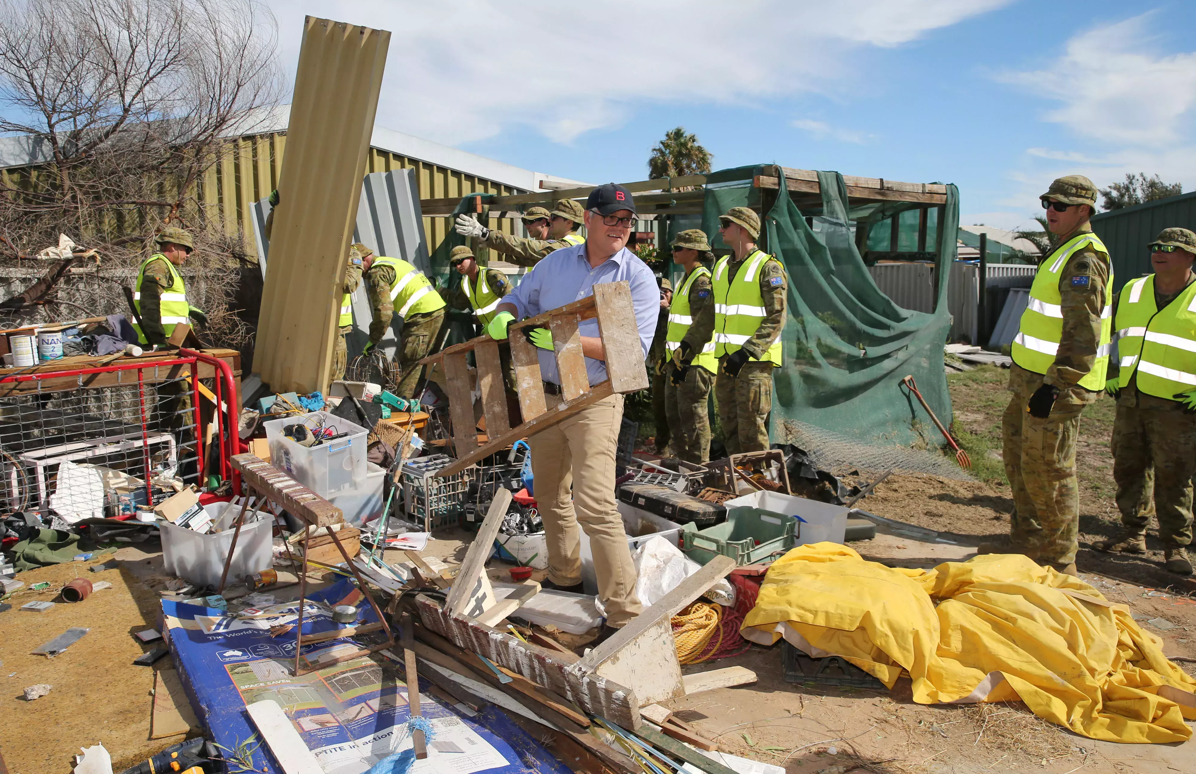 Prime Minister Scott Morrison holding a ladder in the town of Kalbarri in Western Australia that has been damaged by a cyclone. 