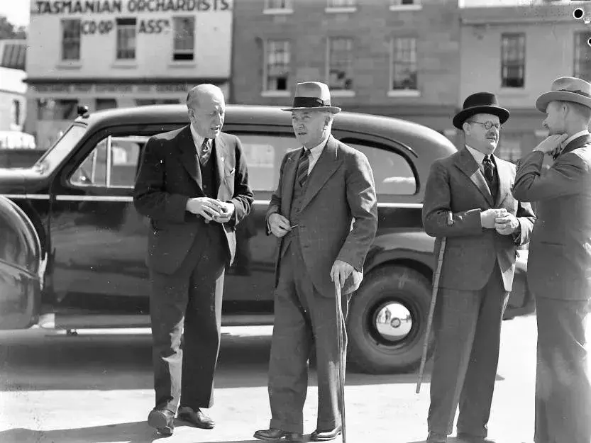 Joseph Lyons standing in front of a car holding a cane 