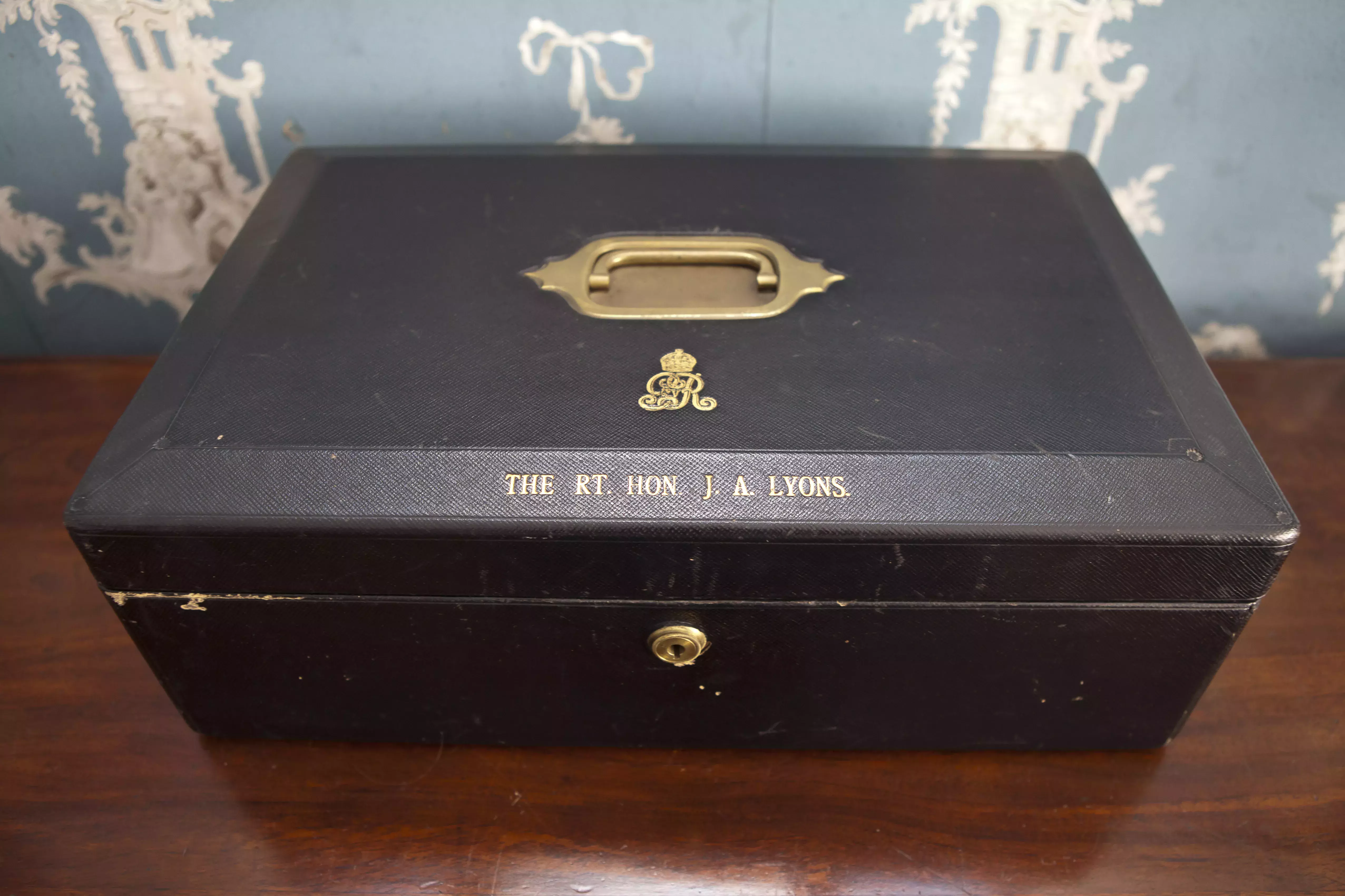 A brown document box with a gold handle.