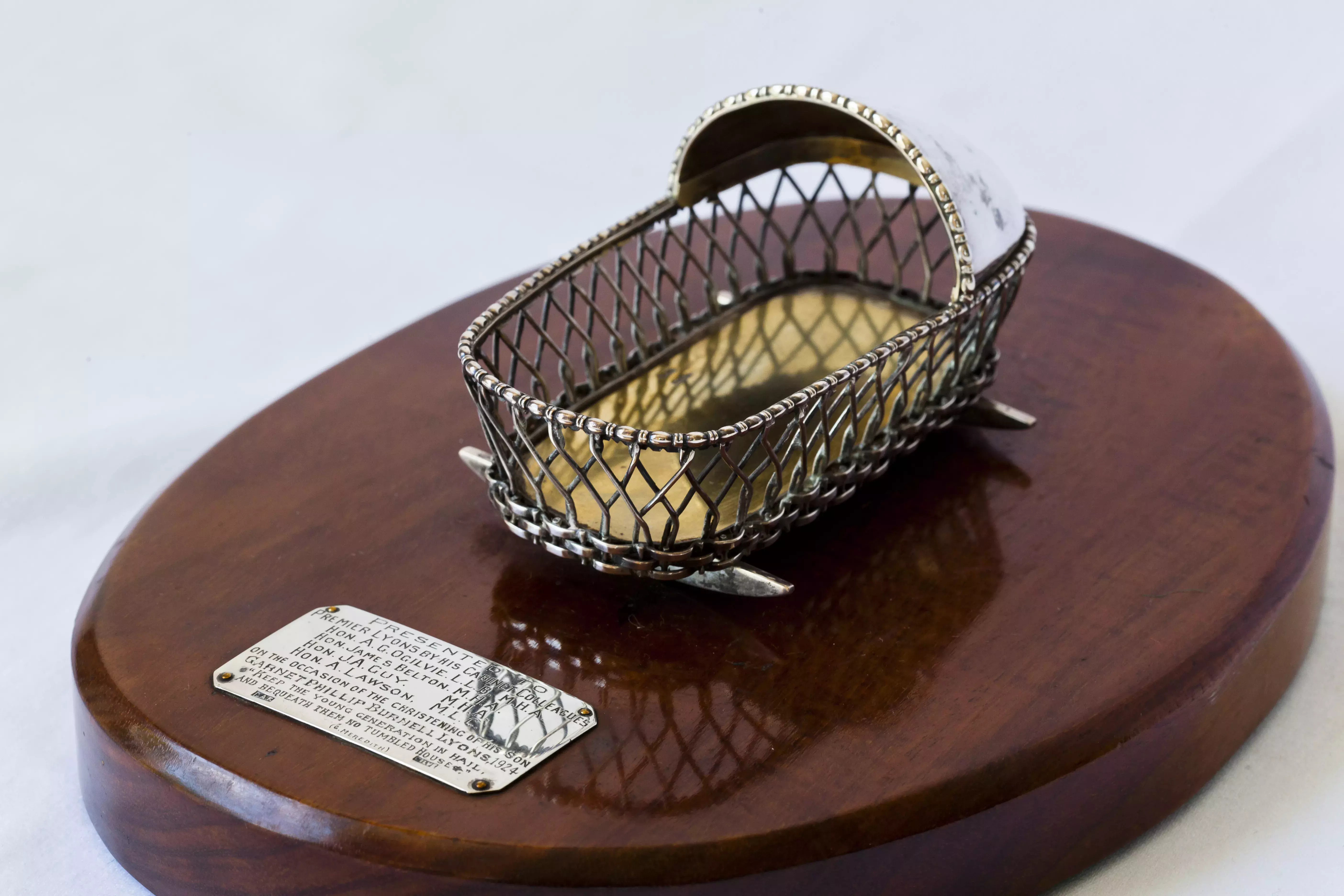 A small silver decorative cradle.