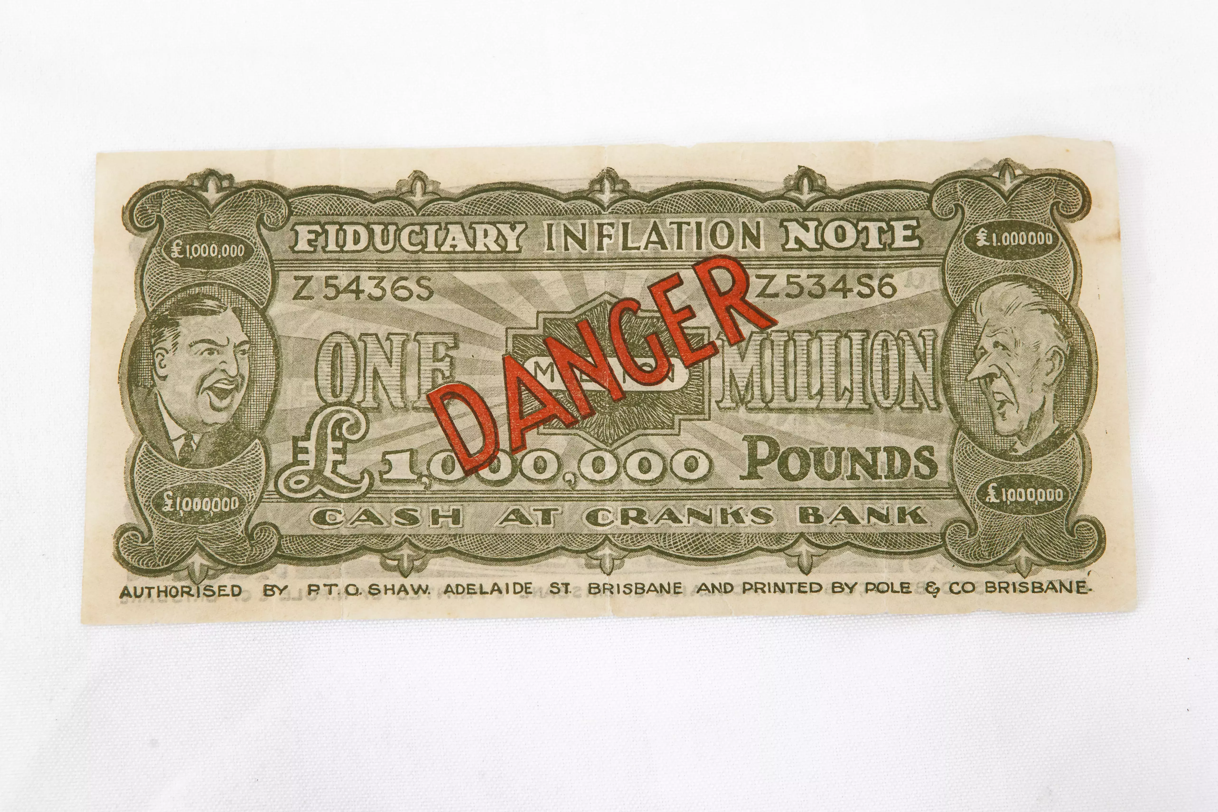 A million pound bank note with the word 'danger' in red text in the middle.  